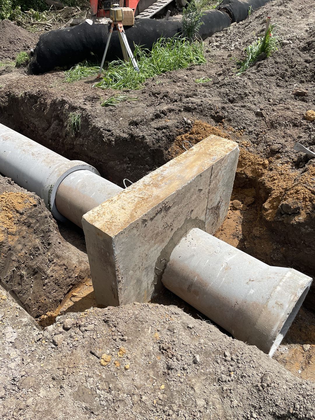 Close view of the anti-seep collar cast around the concrete outlet pipe before backfill