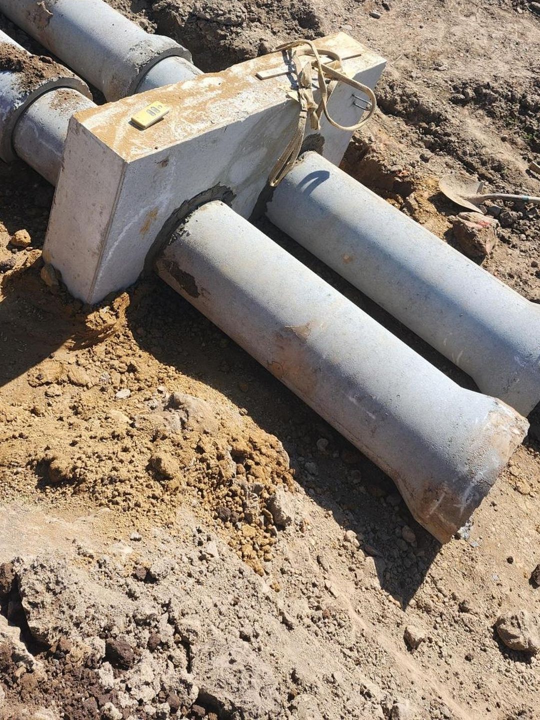 The two downstream outlet barrels leaving the anti-seep collar, with the unreachable wedge of ground under and between them